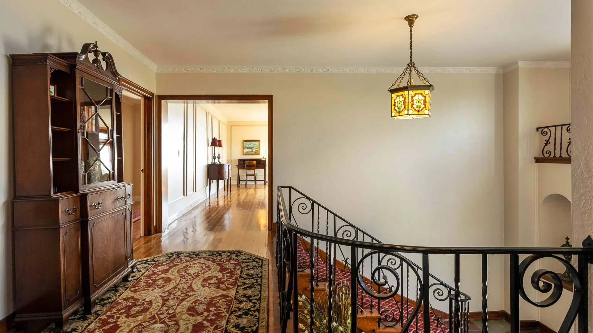 A fancy hallway with stairs and lighting.