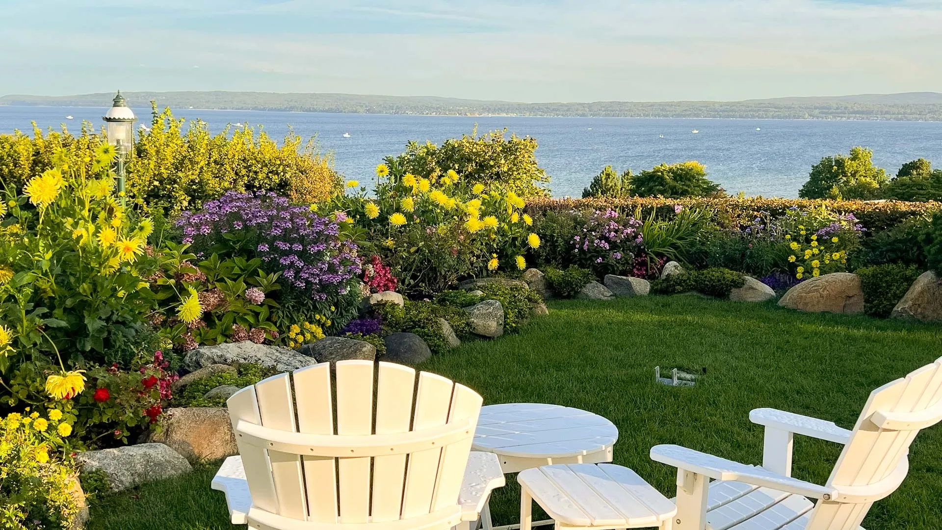 A lakeside view with seating and grass.