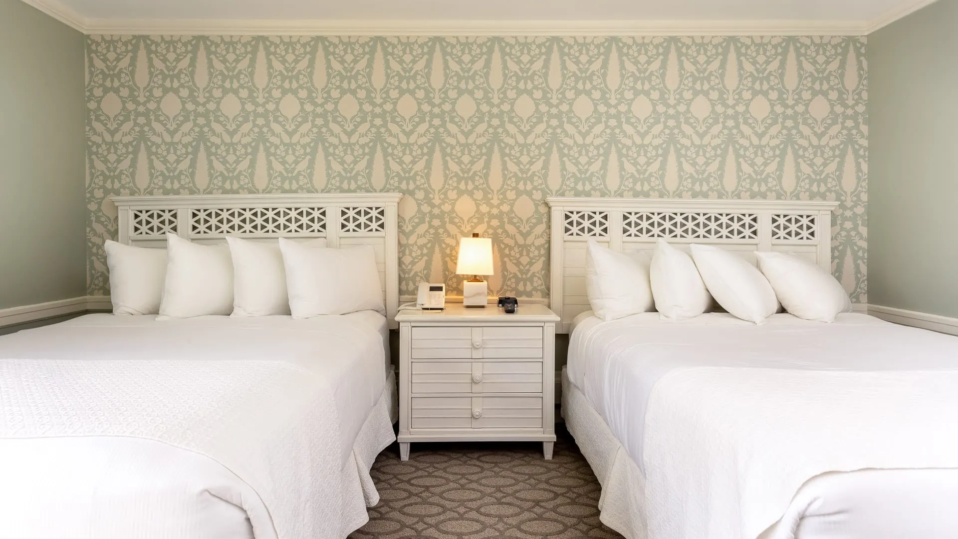 Two beds side by side in a hotel room.