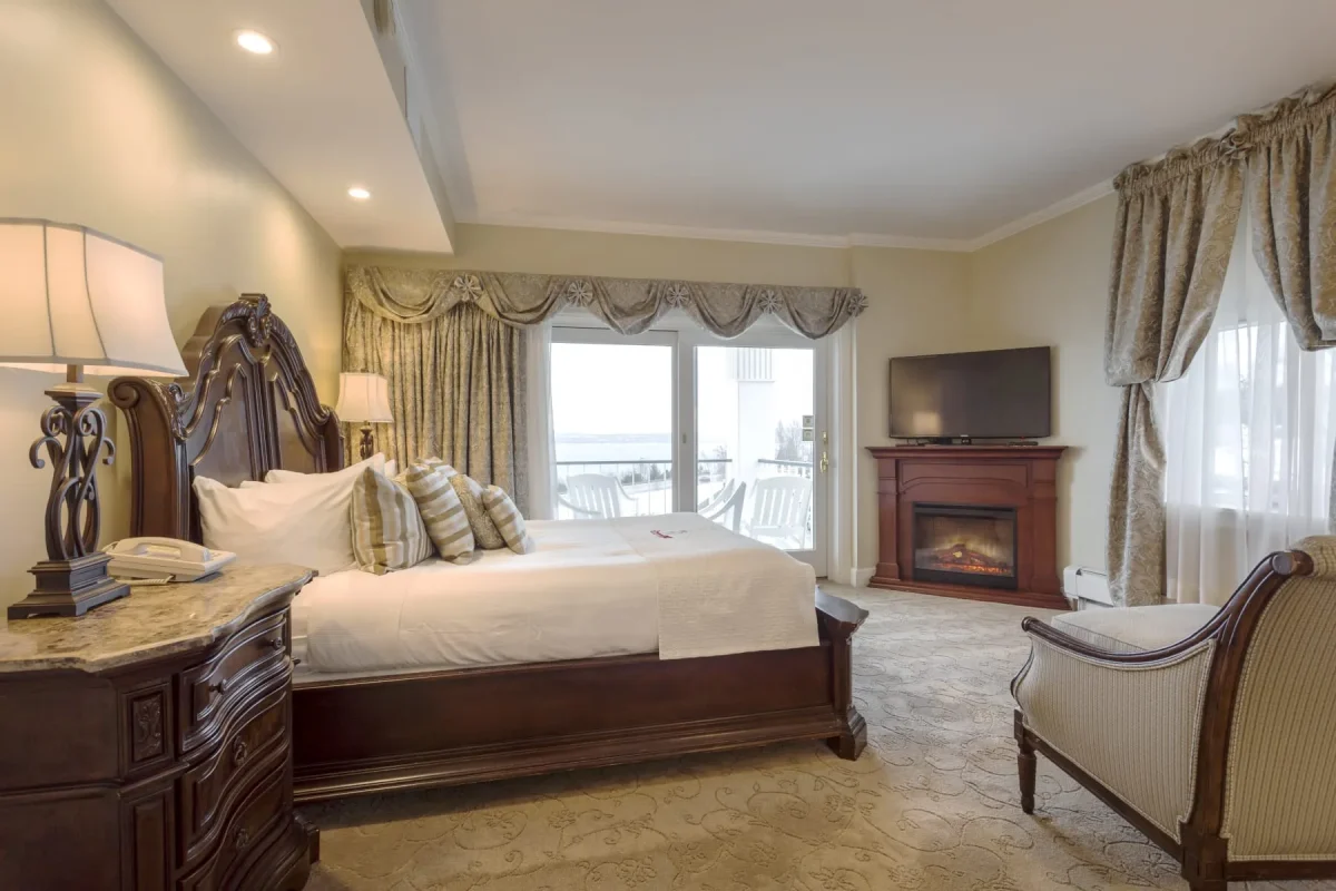 Hotel bedroom with grey carpet, large bed with view of balcony.