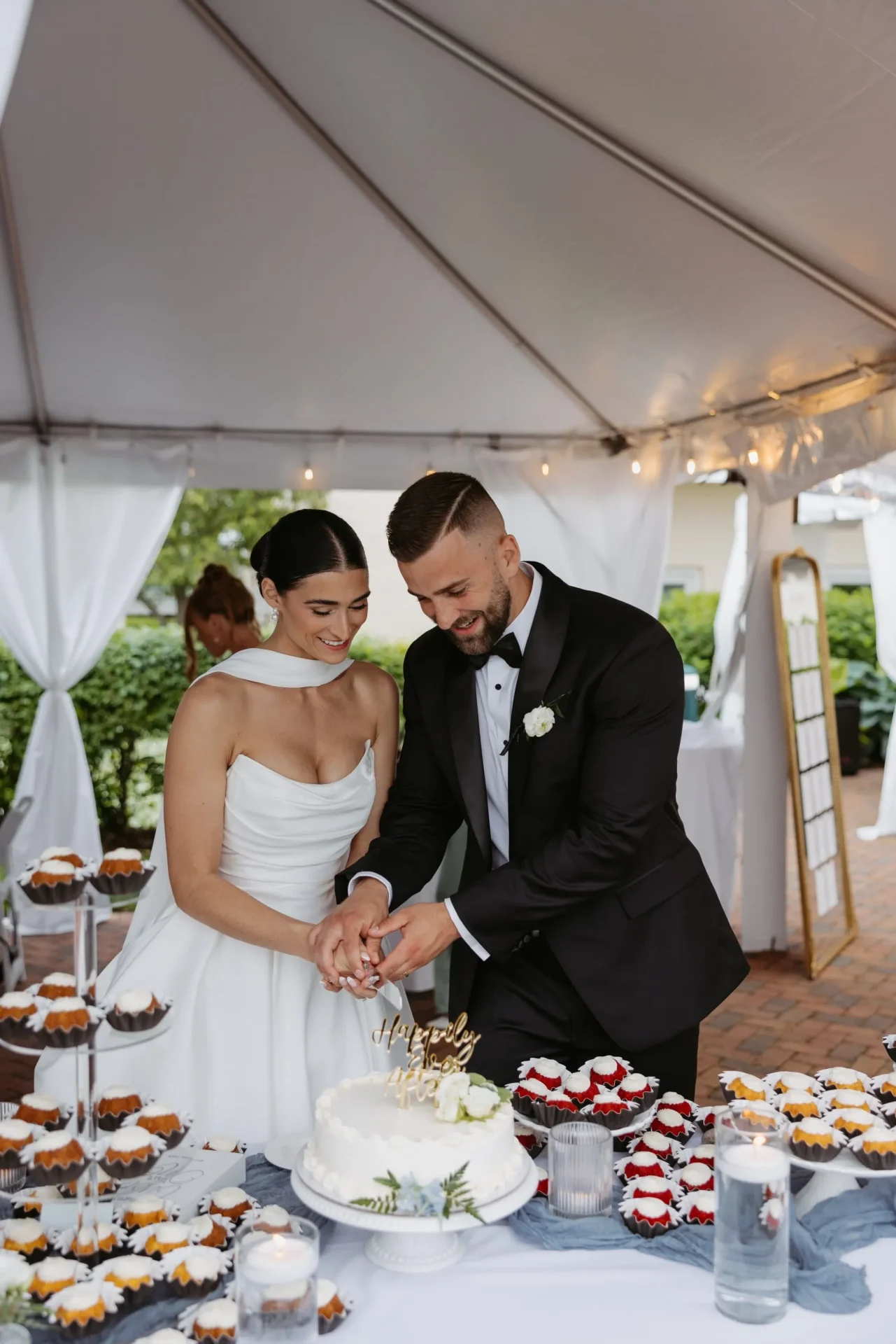 Bride and groom cutting cake at wedding reception.