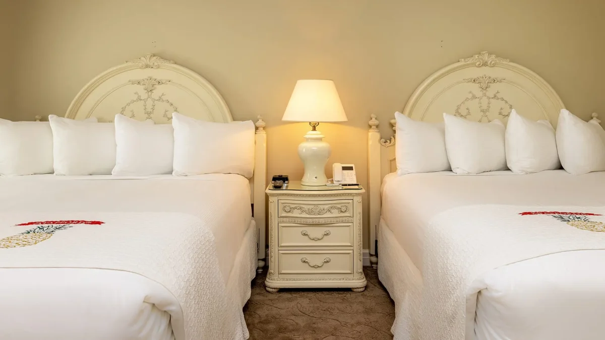 Hotel bedroom with brown carpet with twin bed.