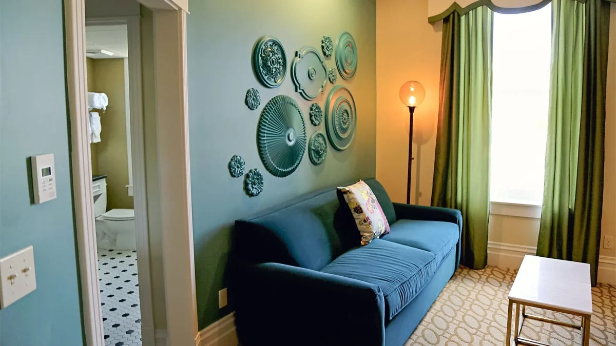 Green walled hotel room leading into bathroom.