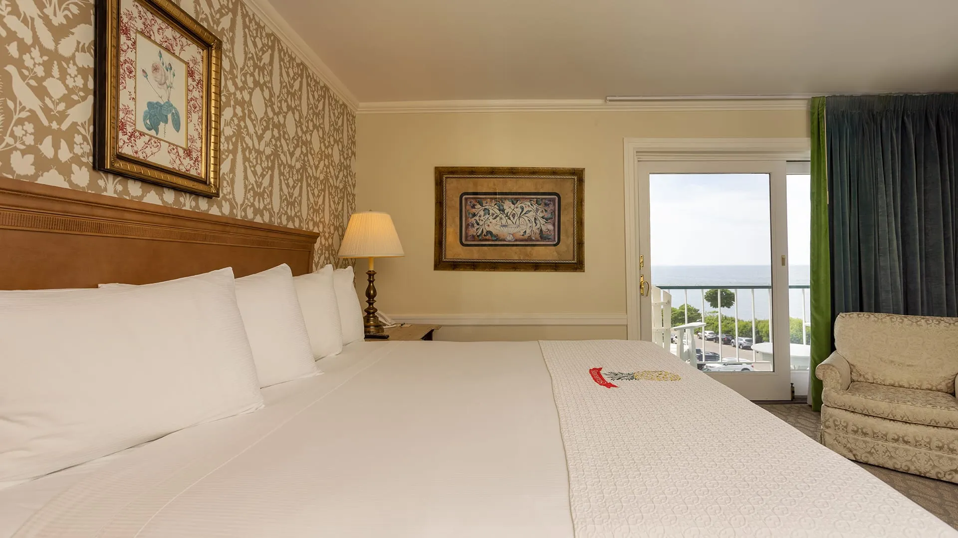 View of large bed and balcony in hotel bedroom.