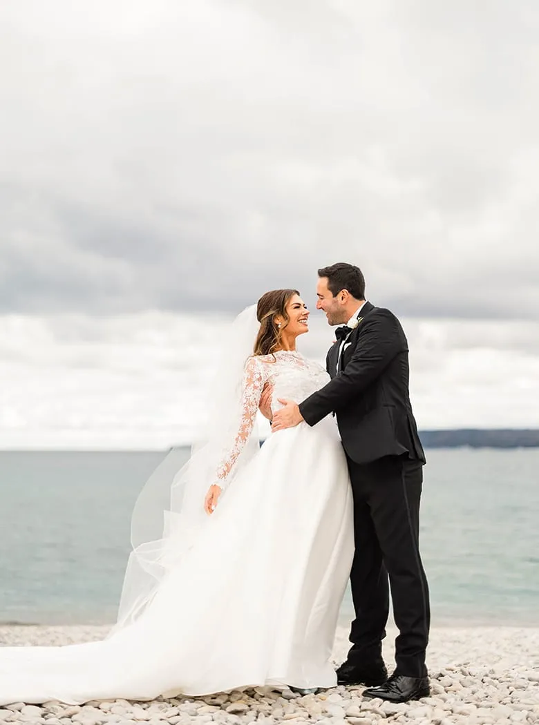 A bride and groom on a beach.