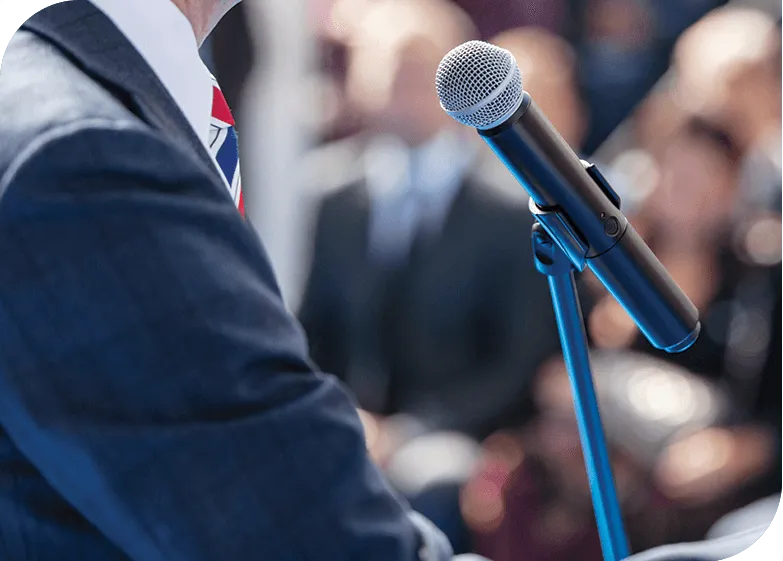 A man speaking in front of others at a microphone.